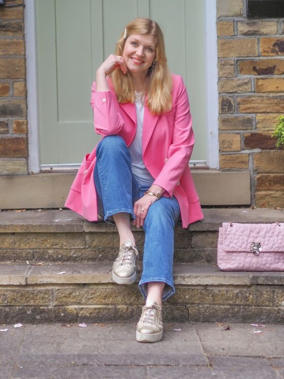 Bright pink blazer with jeans and gold sneakers